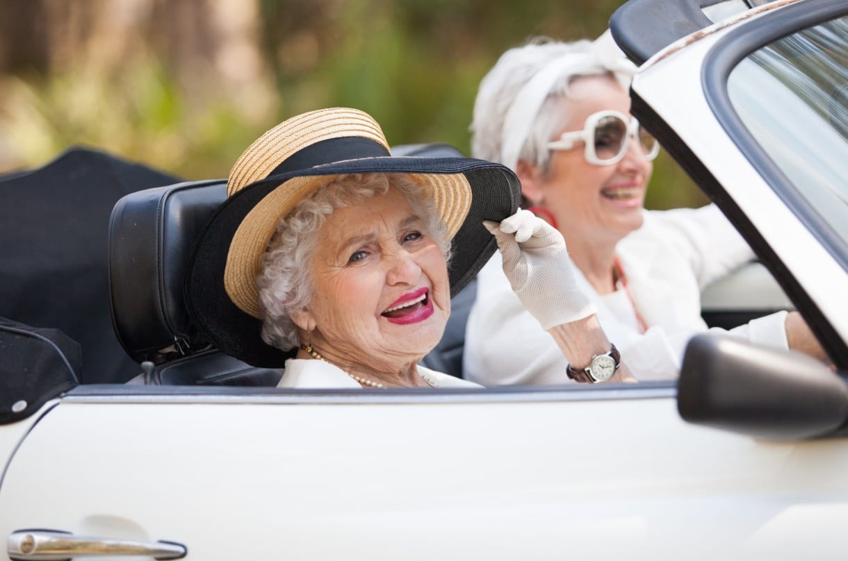 Editorial photography shot of two elderly ladies in white in a white car